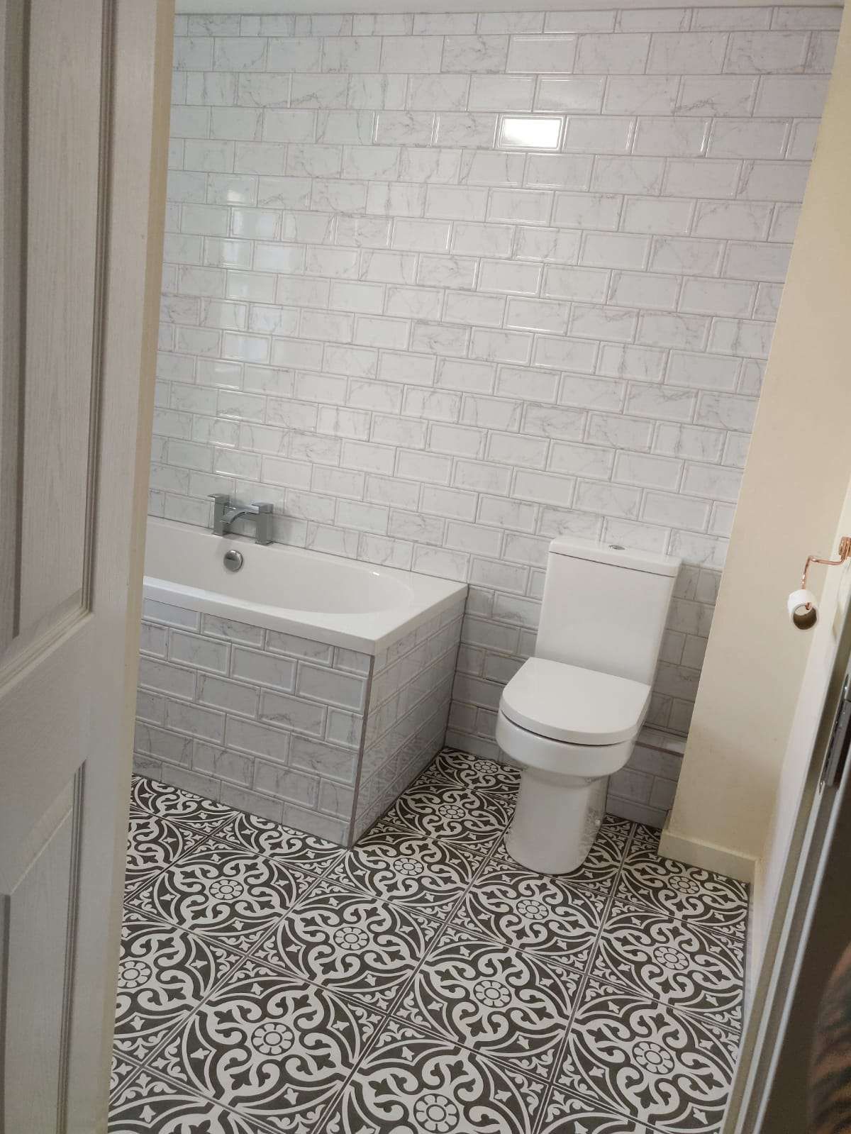 Bathroom with white metro wall tiles and patterned floor