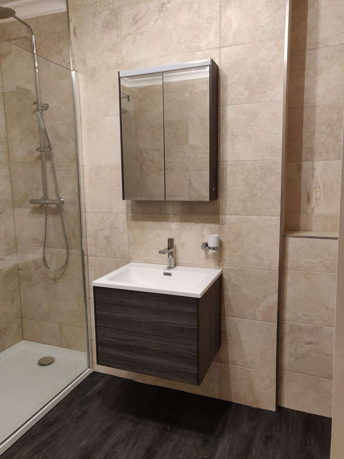 Walk-in shower with natural stone tiling and floating vanity