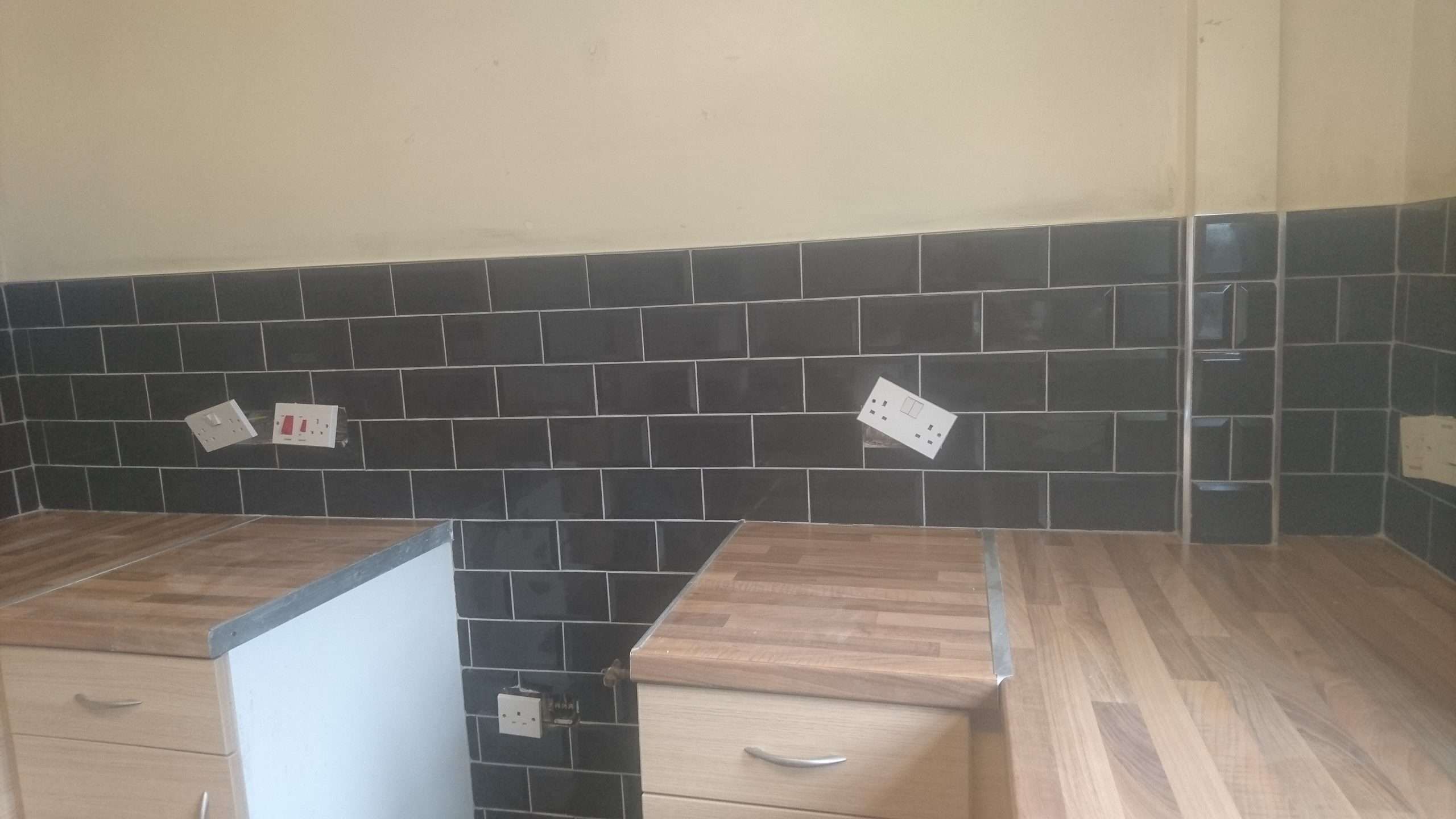 Kitchen splashback tiling above a wooden worktop