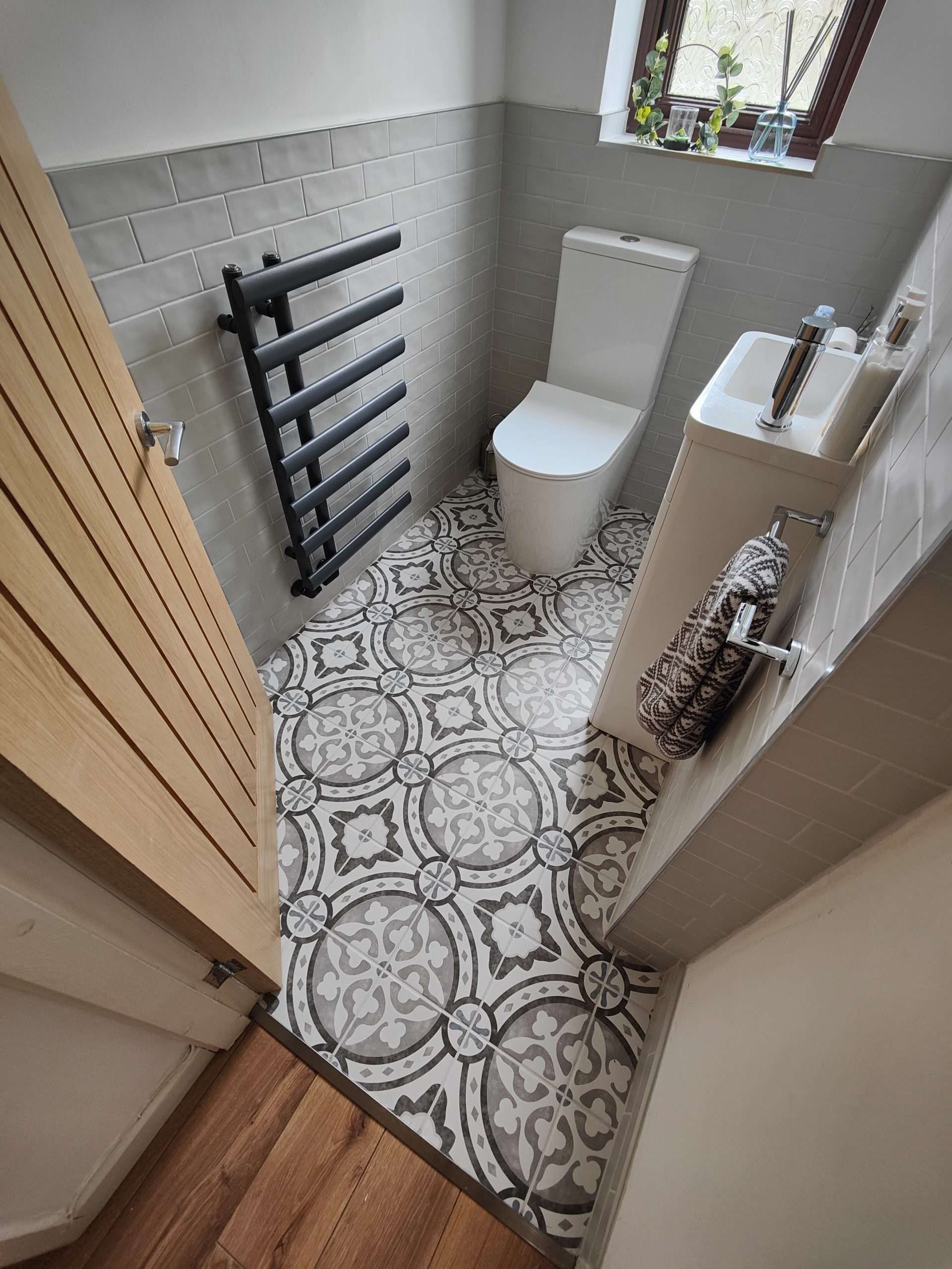 Patterned floor tiles transitioning into wood-effect flooring