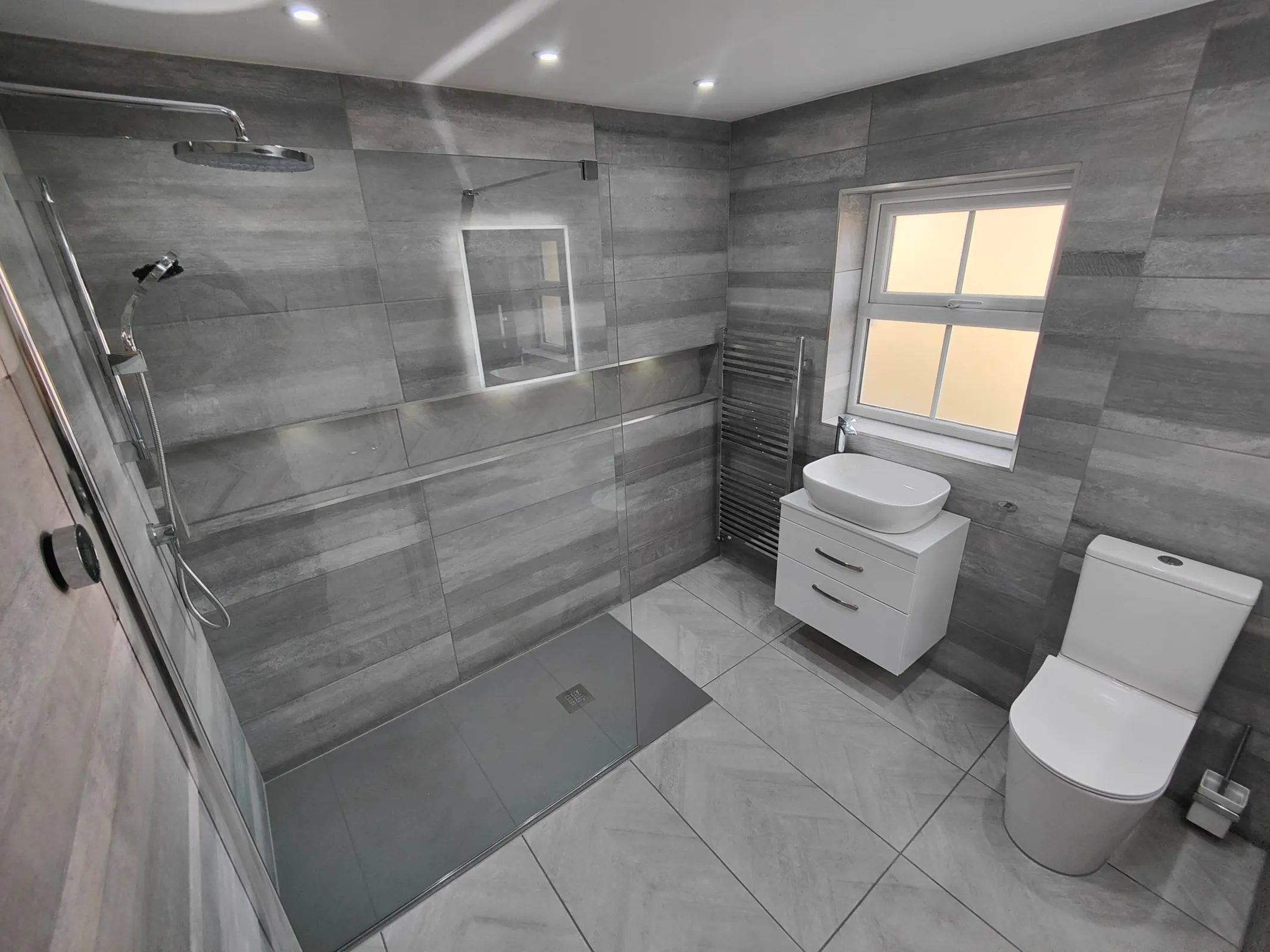 Modern wetroom conversion with floating sink and grey tiles
